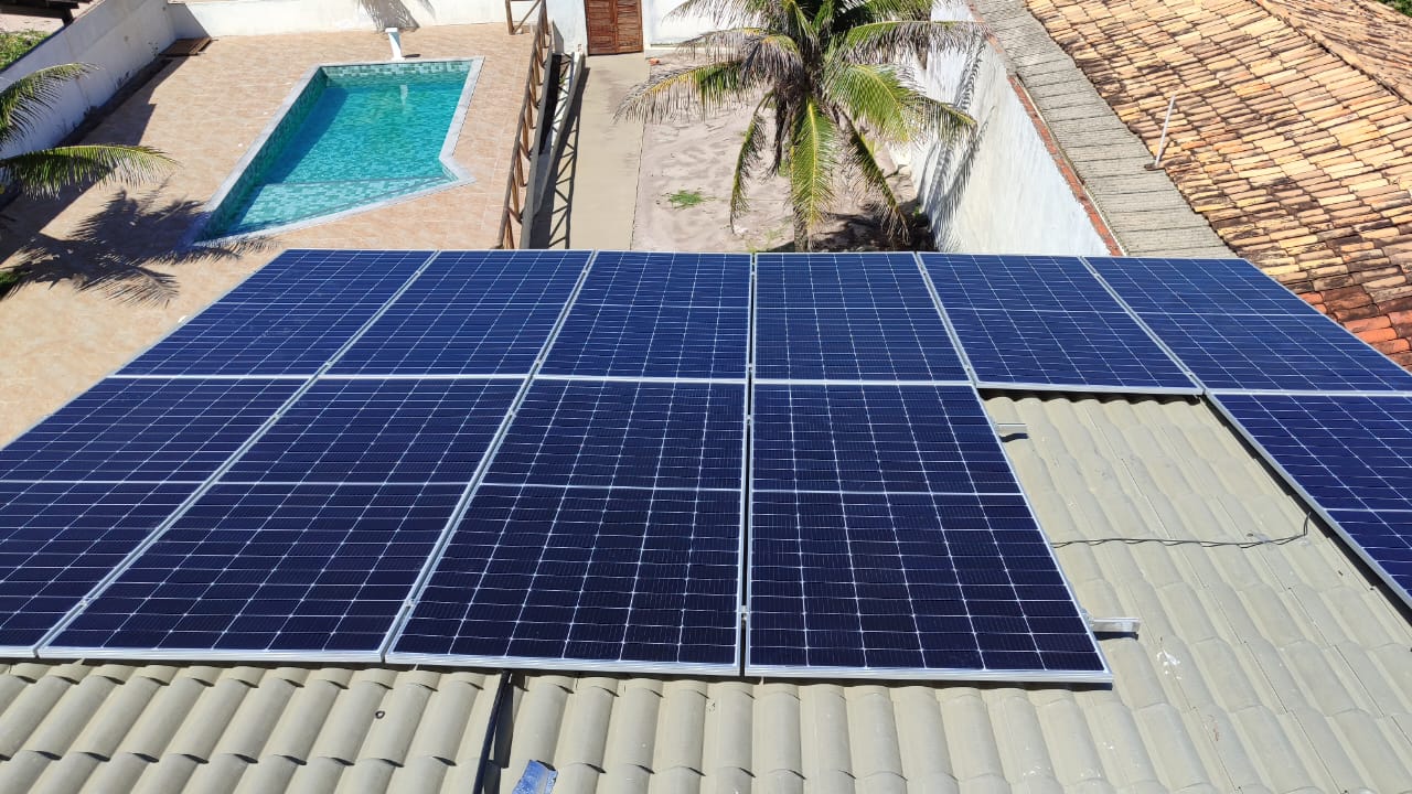 Sistema de energia solar em telhado de residência com piscina.